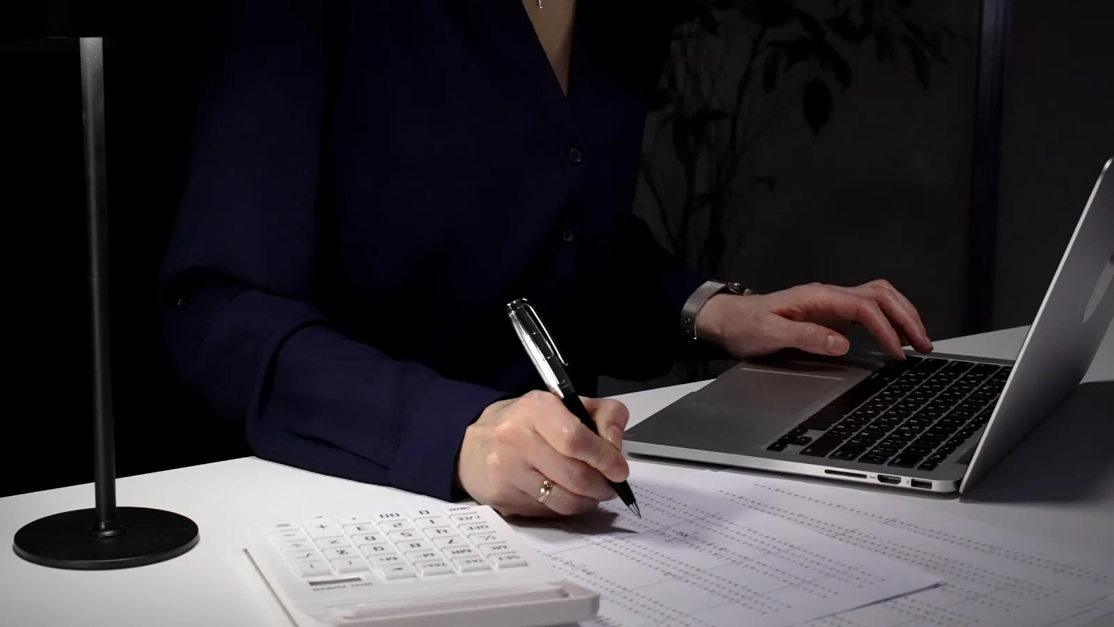 Accountant reviewing financial reports with a laptop and calculator