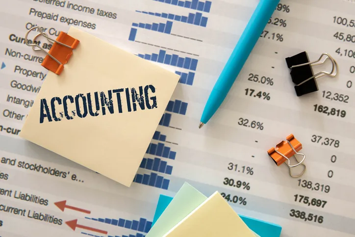 Financial statements with an accounting note, pen and binder clips