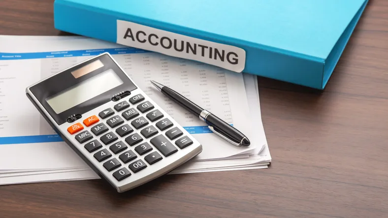 Accounting binder, calculator and financial statements on a desk