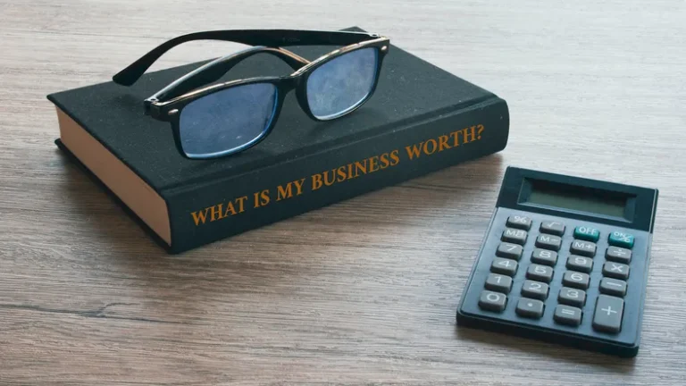 Book titled What Is My Business Worth with glasses and a calculator