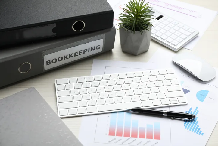 Bookkeeping binders, keyboard and financial charts on a desk